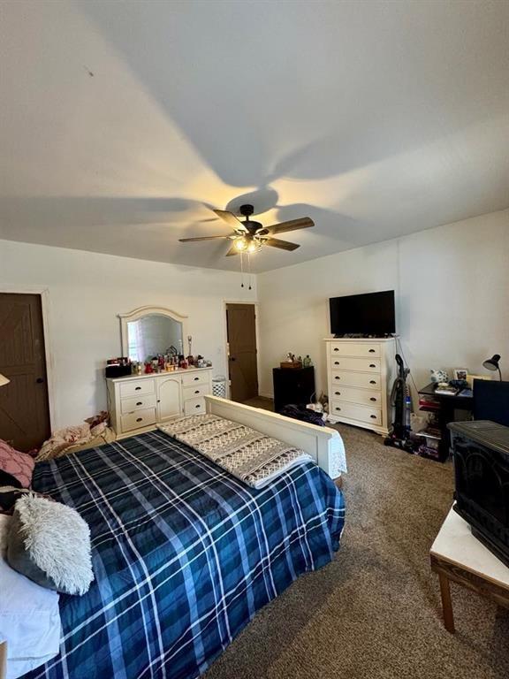 426 Loder St, Barton, NY 14892 - bedroom with carpet, a ceiling fan, and a wood stove