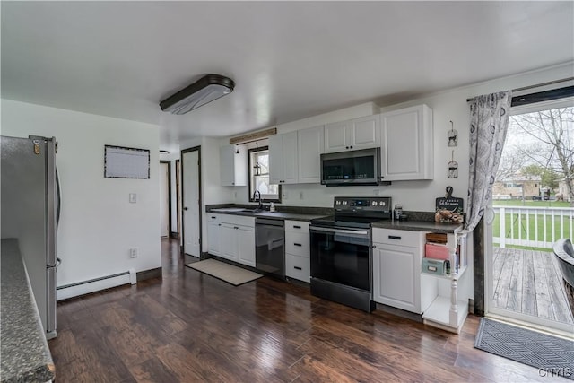 36852 Middle Rd, Orleans, NY 13656 - kitchen featuring stainless steel appliances, baseboard heating, dark countertops, dark wood finished floors, and white cabinets