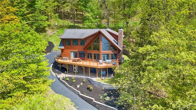 1267 S Lake Rd, Middlesex, NY 14507 - back of property with log siding, a wooden deck, a chimney, and a view of trees