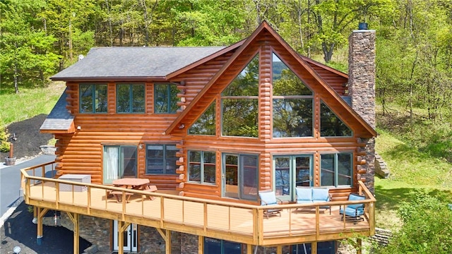 1267 S Lake Rd, Middlesex, NY 14507 - back of house with log siding, a chimney, a wooden deck, and a view of trees