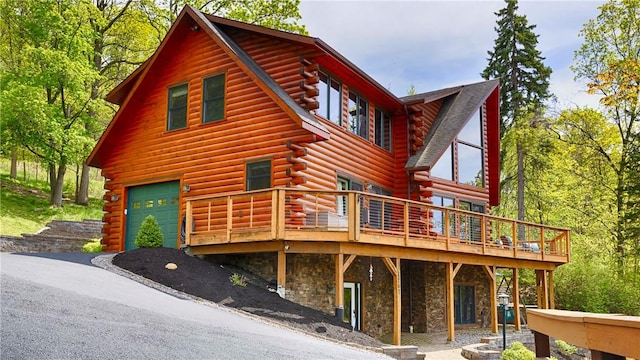 1267 S Lake Rd, Middlesex, NY 14507 - view of front of house featuring log exterior, a deck, an attached garage, and stone siding