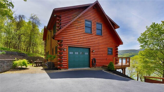 1267 S Lake Rd, Middlesex, NY 14507 - view of home's exterior featuring log exterior, an attached garage, and driveway