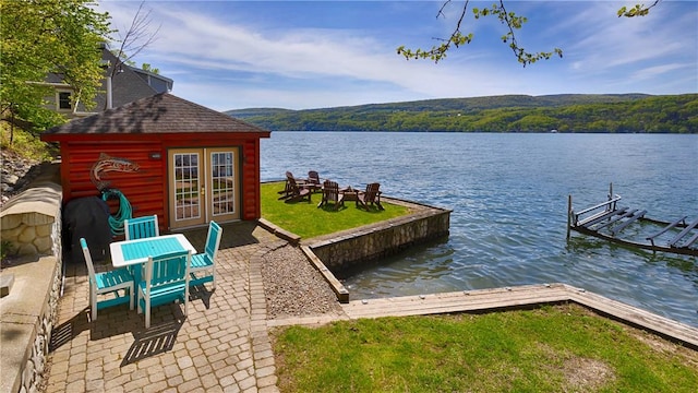 1267 S Lake Rd, Middlesex, NY 14507 - dock area with a water view, a patio, a view of trees, and boat lift