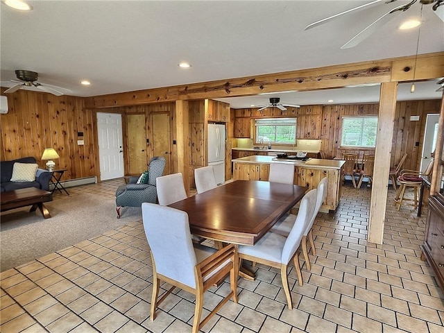 dining room featuring wooden walls, baseboard heating, a ceiling fan, and recessed lighting