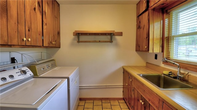 laundry room with washing machine and dryer, cabinet space, and baseboards