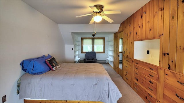 bedroom with light colored carpet, ceiling fan, and wooden walls
