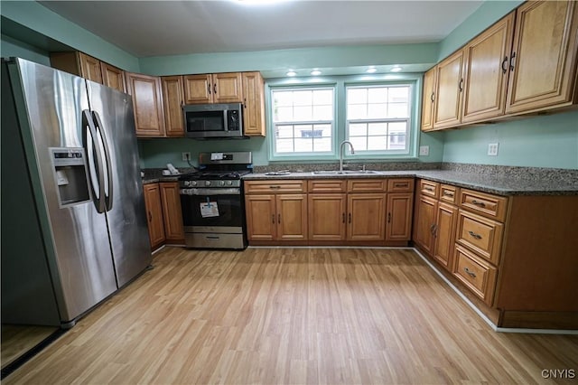 11 White St, Kirkland, NY 13323 - kitchen featuring appliances with stainless steel finishes, a sink, light wood-style flooring, and brown cabinetry