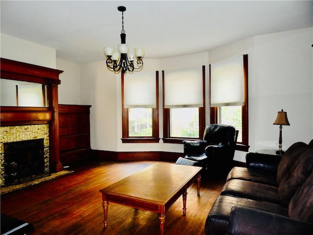 7 Walnut St, Oneonta-City, NY 13820 - living area featuring wood finished floors, a chandelier, a fireplace, and baseboards