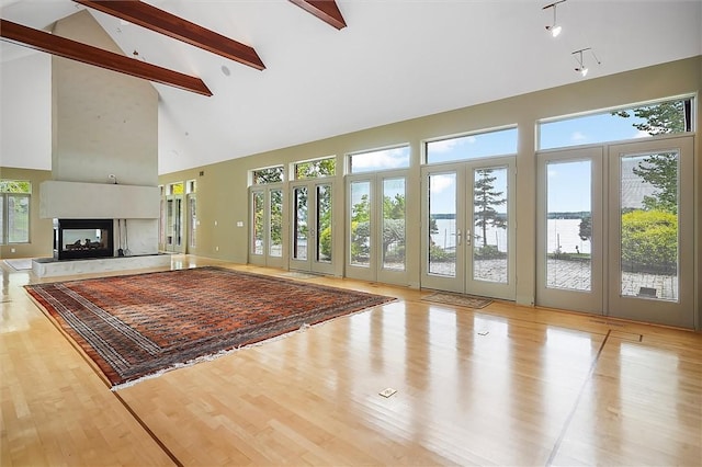 4331 Tichenor Point Dr, Canandaigua-Town, NY 14424 - unfurnished living room featuring high vaulted ceiling, french doors, beam ceiling, a multi sided fireplace, and wood finished floors