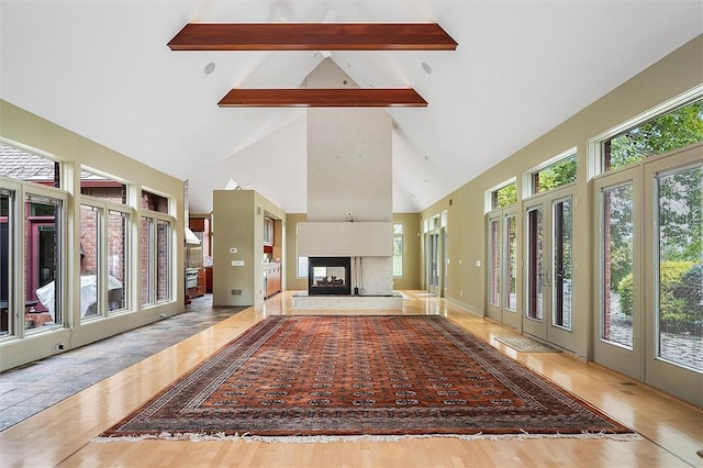 4331 Tichenor Point Dr, Canandaigua-Town, NY 14424 - unfurnished living room with beamed ceiling, wood finished floors, a multi sided fireplace, and high vaulted ceiling