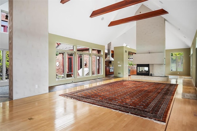 4331 Tichenor Point Dr, Canandaigua-Town, NY 14424 - unfurnished living room featuring high vaulted ceiling, wood finished floors, beam ceiling, and a multi sided fireplace