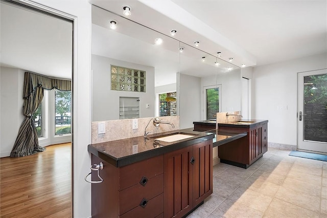 4331 Tichenor Point Dr, Canandaigua-Town, NY 14424 - kitchen featuring a sink, dark countertops, baseboards, a kitchen island, and light tile patterned flooring