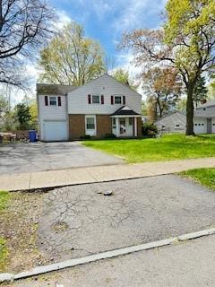 view of front of home featuring concrete driveway, a garage, and a front lawn