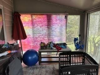 sunroom featuring lofted ceiling and crown molding