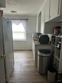 kitchen featuring light wood-style flooring, white cabinetry, and light countertops