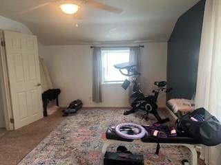 exercise room with vaulted ceiling and carpet floors