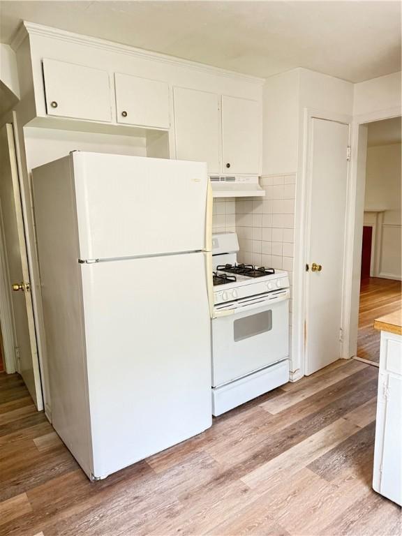 167 Rogers Pkwy, Irondequoit, NY 14617 - kitchen with white appliances, under cabinet range hood, light wood-style flooring, and white cabinetry