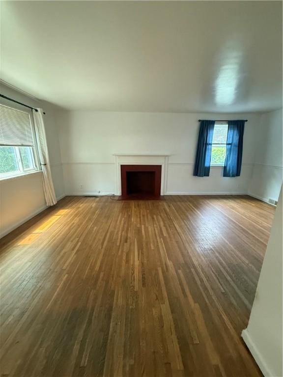 167 Rogers Pkwy, Irondequoit, NY 14617 - unfurnished living room featuring wood finished floors, healthy amount of natural light, and a fireplace with flush hearth