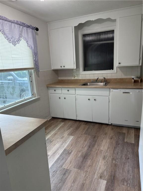 167 Rogers Pkwy, Irondequoit, NY 14617 - kitchen featuring dishwasher, a sink, light wood-style flooring, white cabinets, and light countertops