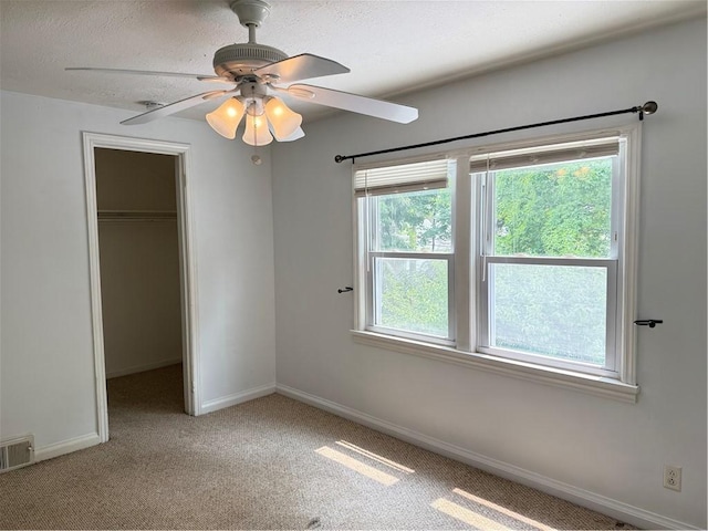 167 Rogers Pkwy, Irondequoit, NY 14617 - unfurnished bedroom featuring carpet, baseboards, a closet, a walk in closet, and a textured ceiling