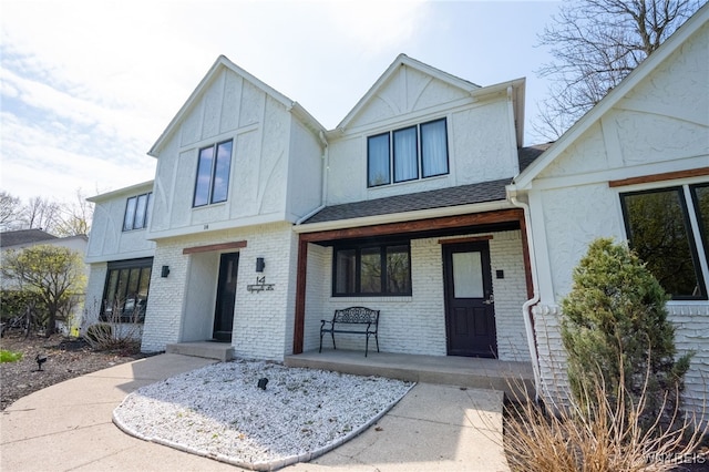 14 Wynngate Ln, Amherst, NY 14221 - view of front of property with covered porch, stucco siding, brick siding, and roof with shingles