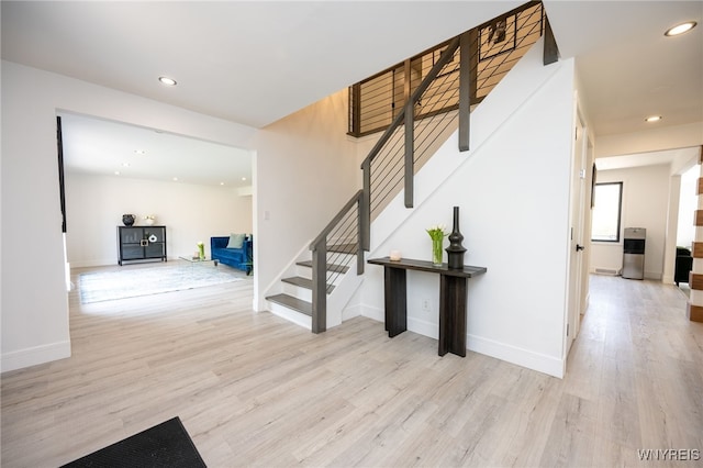 staircase with wood finished floors, recessed lighting, and baseboards