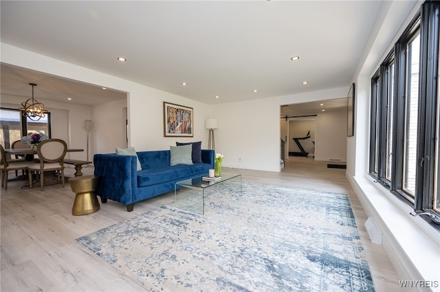 living room with plenty of natural light, light wood-style flooring, a chandelier, recessed lighting, and baseboards