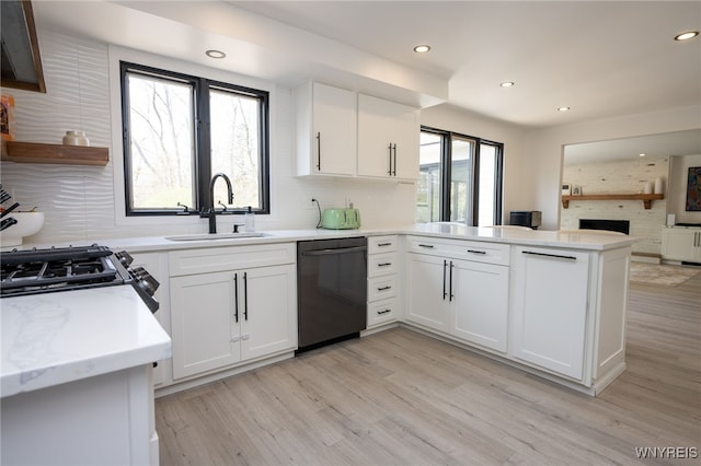 kitchen featuring black dishwasher, a sink, a peninsula, backsplash, and open floor plan