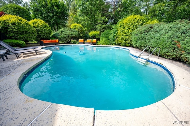 14 Wynngate Ln, Amherst, NY 14221 - swimming pool with a patio area and view of scattered trees