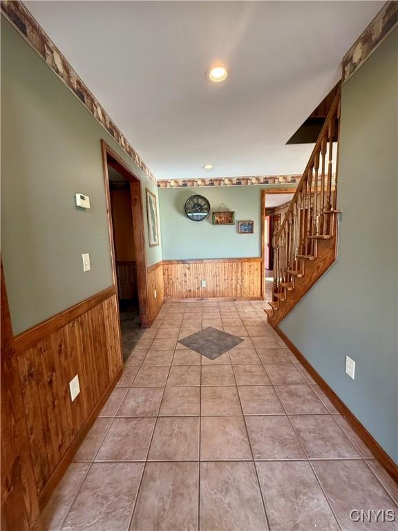 657 W Cottage Ln, Deruyter, NY 13052 - corridor featuring a wainscoted wall, wooden walls, stairway, recessed lighting, and tile patterned floors