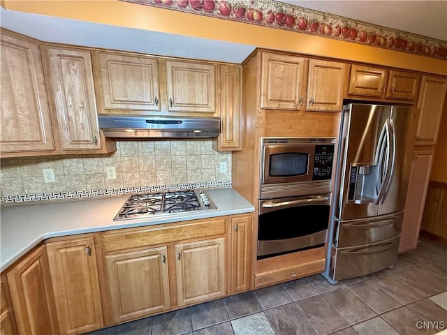 657 W Cottage Ln, Deruyter, NY 13052 - kitchen featuring appliances with stainless steel finishes, under cabinet range hood, light countertops, decorative backsplash, and dark tile patterned floors