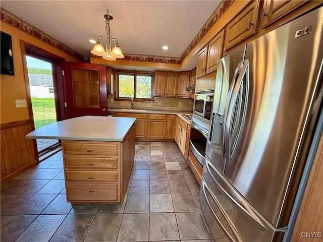 657 W Cottage Ln, Deruyter, NY 13052 - kitchen featuring stainless steel appliances, a sink, plenty of natural light, light countertops, and a wainscoted wall