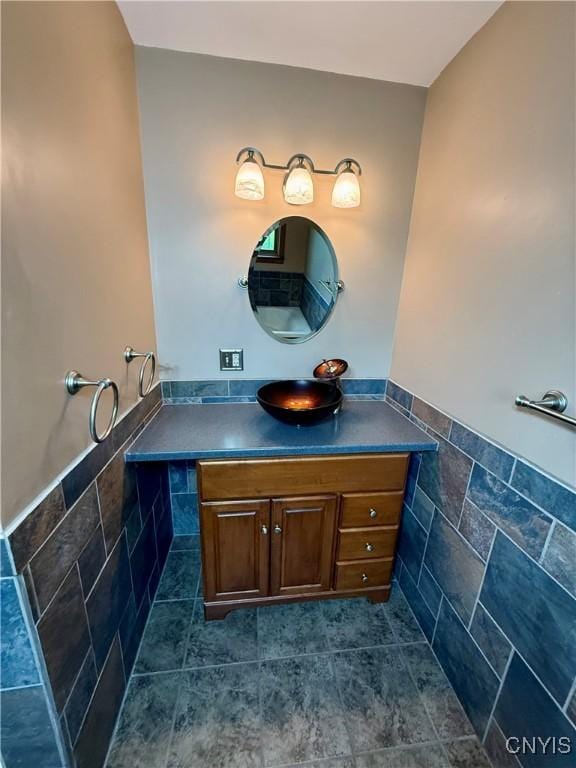 657 W Cottage Ln, Deruyter, NY 13052 - bathroom featuring vanity, a wainscoted wall, tile walls, and tile patterned flooring