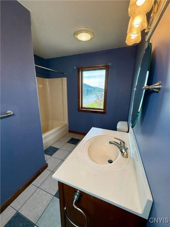 657 W Cottage Ln, Deruyter, NY 13052 - full bath featuring vanity, tile patterned floors,  shower combination, and baseboards