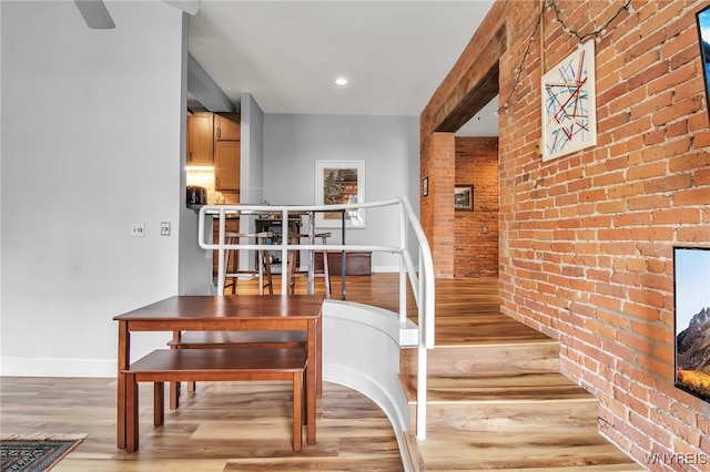 125 Edward St Unit 2G, Buffalo, NY 14201 - staircase with brick wall, wood finished floors, and baseboards