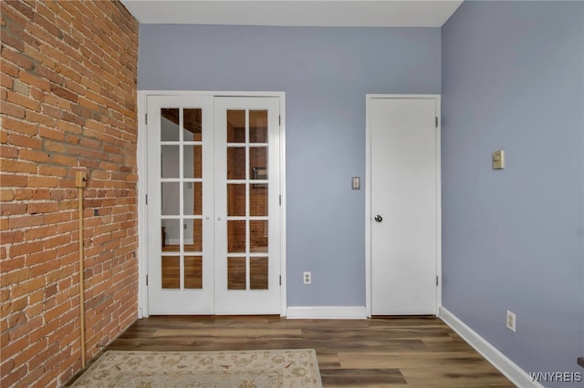 125 Edward St Unit 2G, Buffalo, NY 14201 - unfurnished room with french doors, brick wall, wood finished floors, and baseboards
