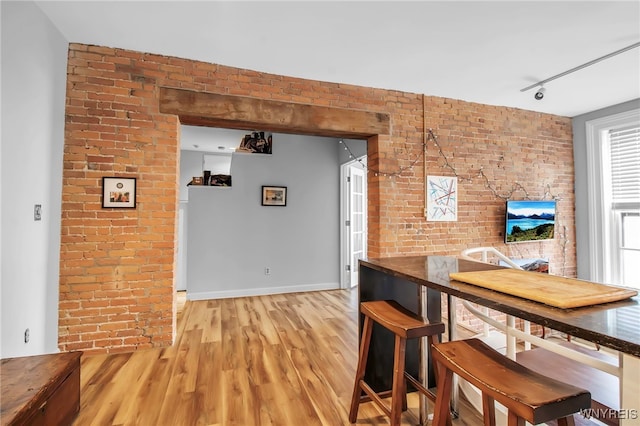 125 Edward St Unit 2G, Buffalo, NY 14201 - dining area featuring brick wall, light wood-style floors, rail lighting, and baseboards