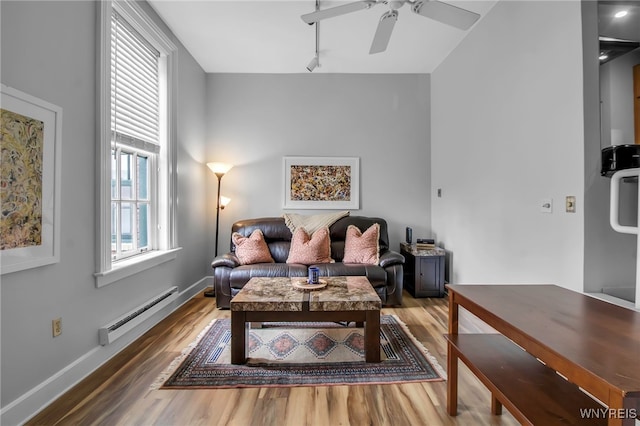 125 Edward St Unit 2G, Buffalo, NY 14201 - living area with a baseboard radiator, rail lighting, wood finished floors, and a ceiling fan