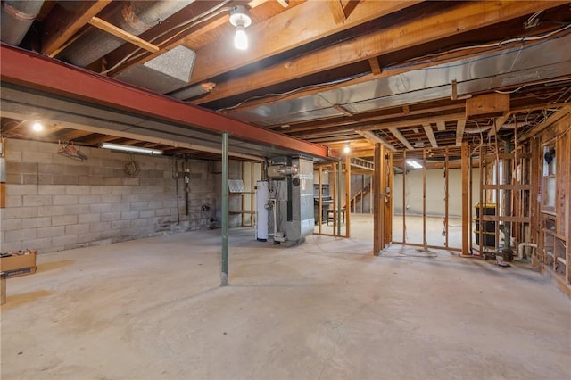 unfinished below grade area featuring heating unit, concrete block wall, and gas water heater