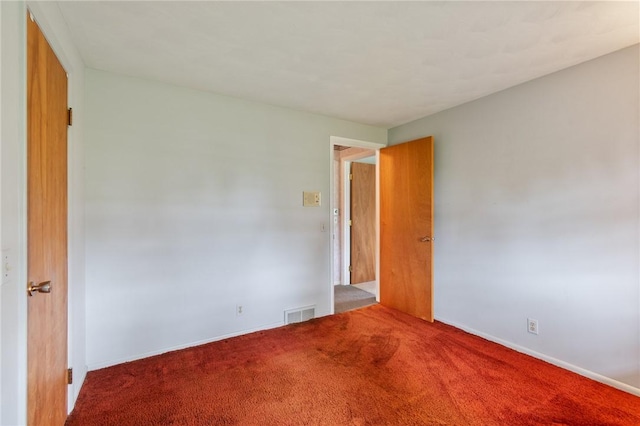 unfurnished room with carpet floors and baseboards