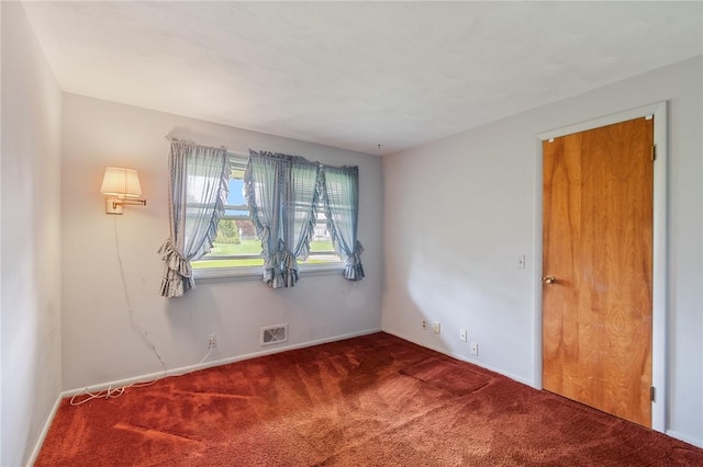 empty room featuring carpet floors and baseboards