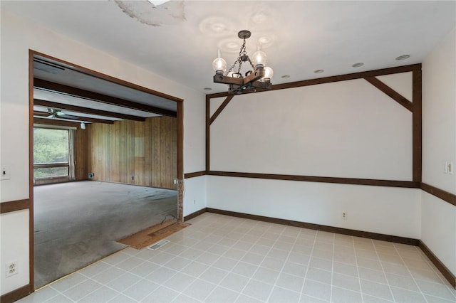 unfurnished room featuring a chandelier, baseboards, light carpet, and beamed ceiling