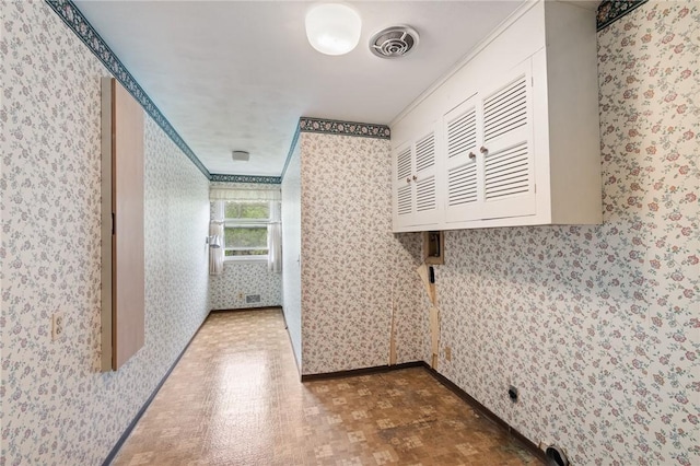 laundry area with wallpapered walls, baseboards, and crown molding