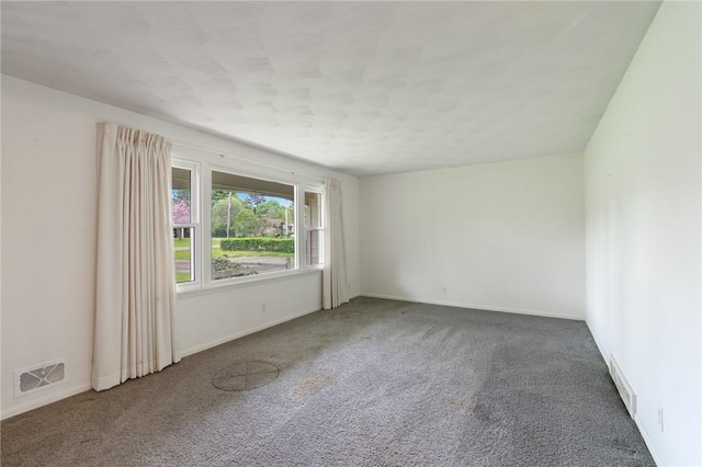 carpeted empty room featuring baseboards and a textured ceiling