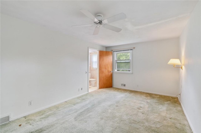 carpeted spare room with a ceiling fan and baseboards
