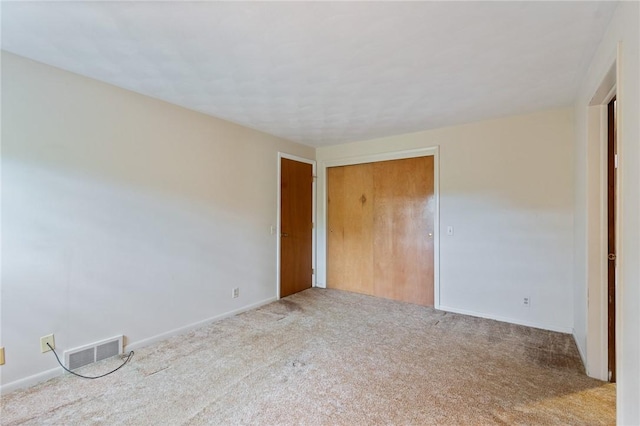 unfurnished bedroom with carpet, a closet, and baseboards