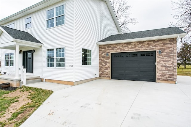1965 Main St, Carlton, NY 14571 - view of side of home with concrete driveway, an attached garage, and stone siding