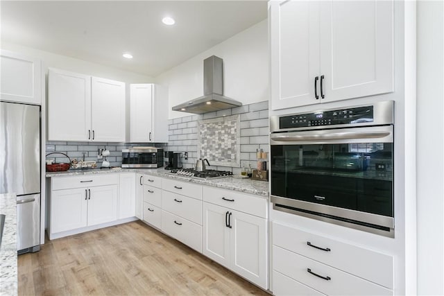 1965 Main St, Carlton, NY 14571 - kitchen featuring stainless steel appliances, ventilation hood, white cabinets, decorative backsplash, and recessed lighting