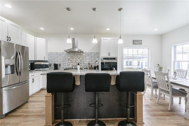 1965 Main St, Carlton, NY 14571 - kitchen with appliances with stainless steel finishes, ventilation hood, decorative backsplash, a breakfast bar area, and light stone counters