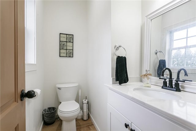 1965 Main St, Carlton, NY 14571 - bathroom with toilet, baseboards, vanity, and wood finished floors